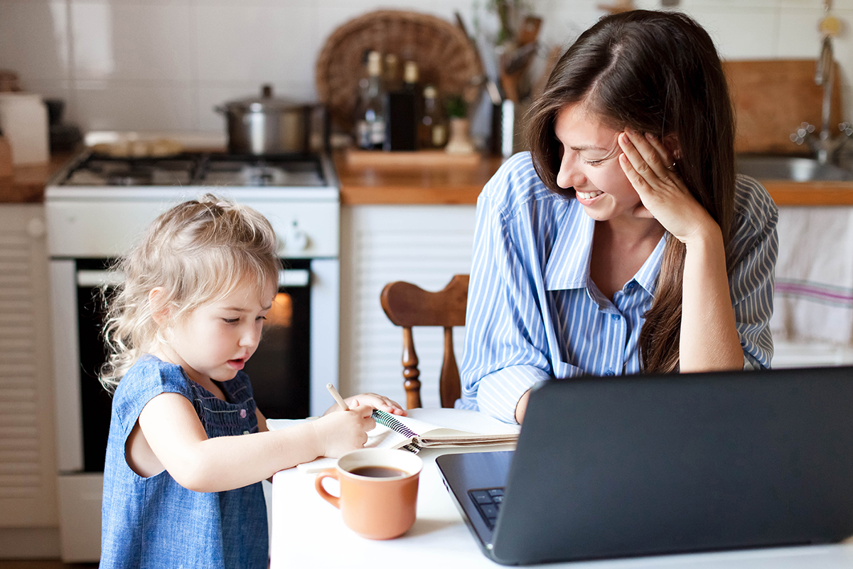 Woman working from home while watching small child